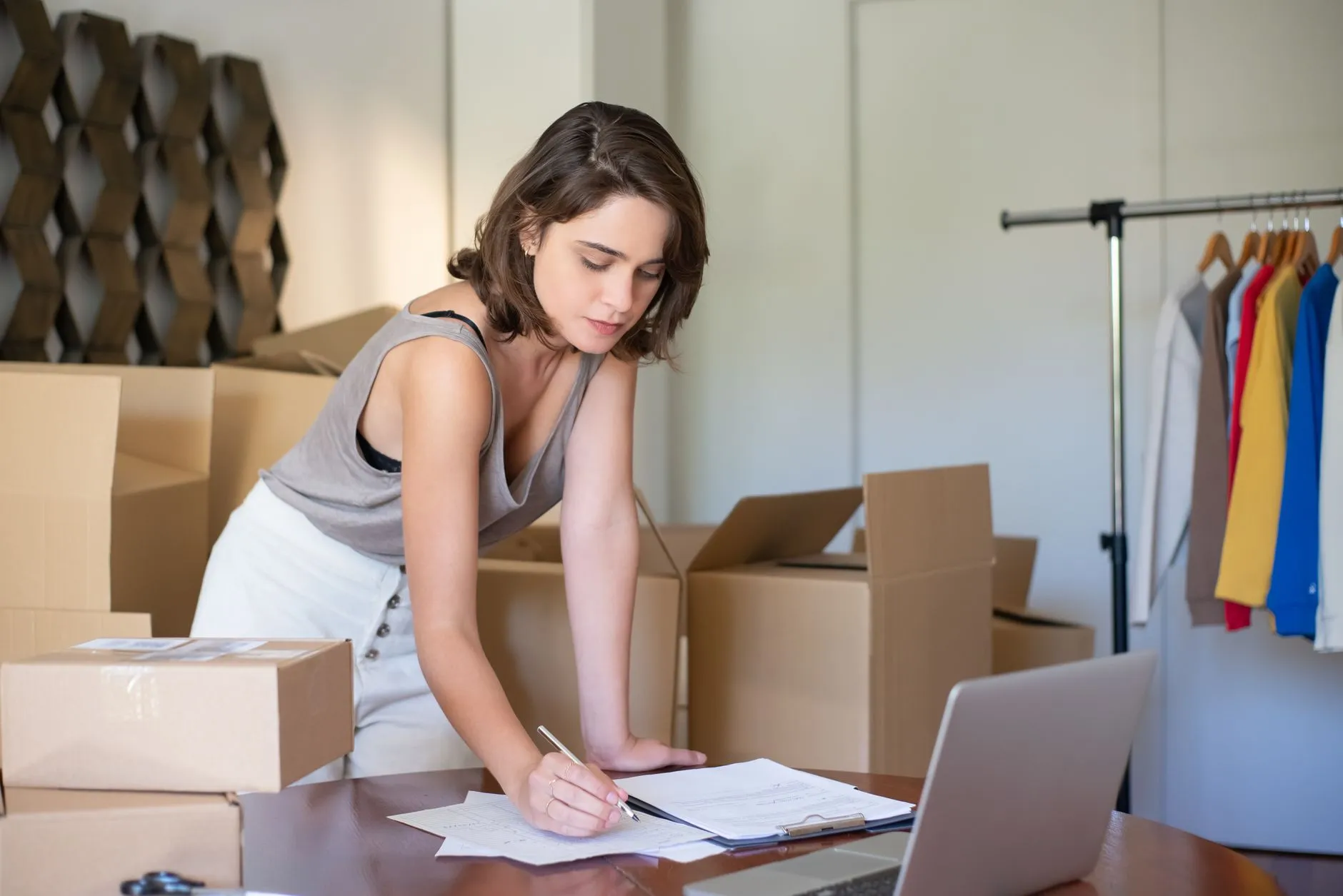 An online store owner managing products on a laptop